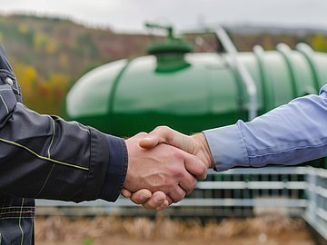Kundenkontakt vor einer Biogasanlage