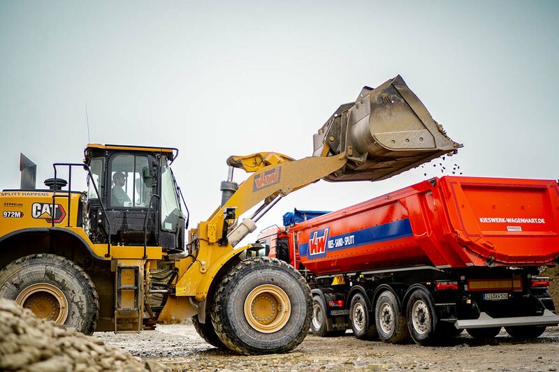 Bagger belädt einen Tieflader
