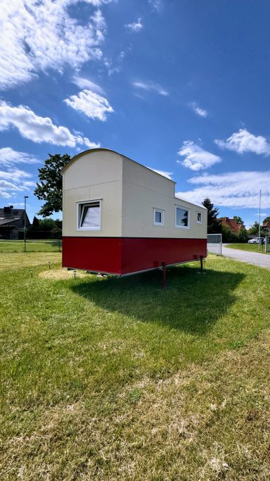 Tiny House Red One auf einer Wiese