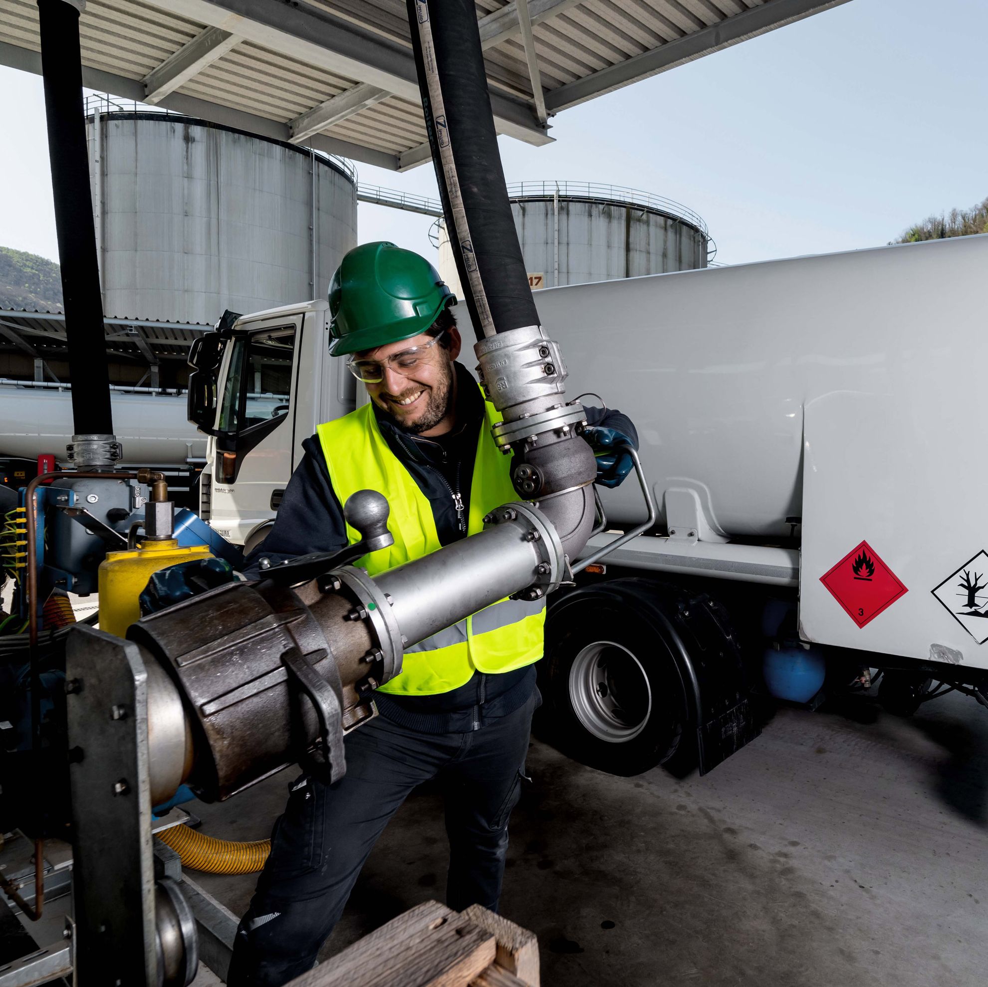 Mitarbeiter mit Sicherheitshelm an einer Tankanlage