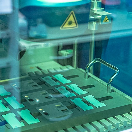 Blick durch das Laserschutzglas auf Laserkopf und Werkstückpalette