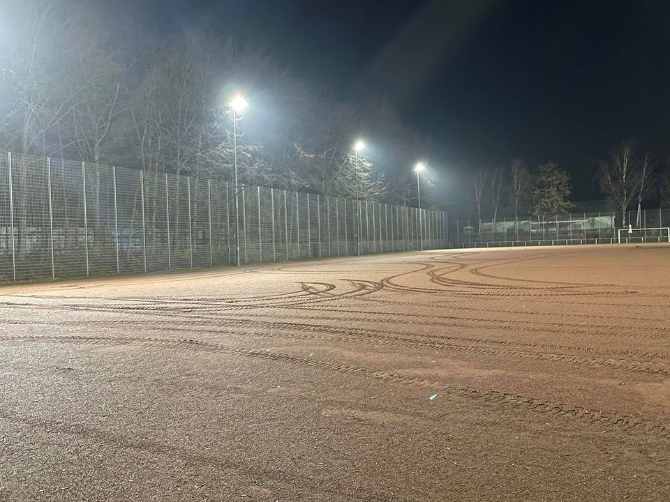 Sportplatz bei Nacht mit eingeschalteter Flutlichtanlage