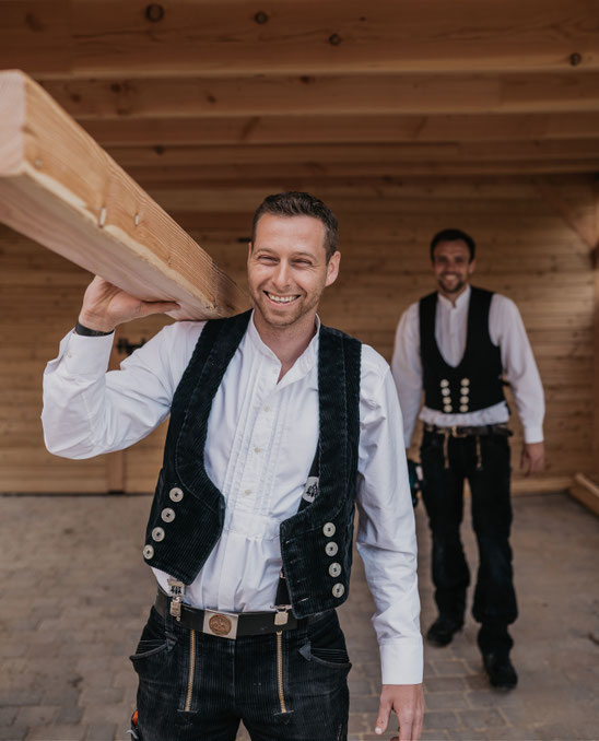 Zimmerer unter einem Carport aus Holz