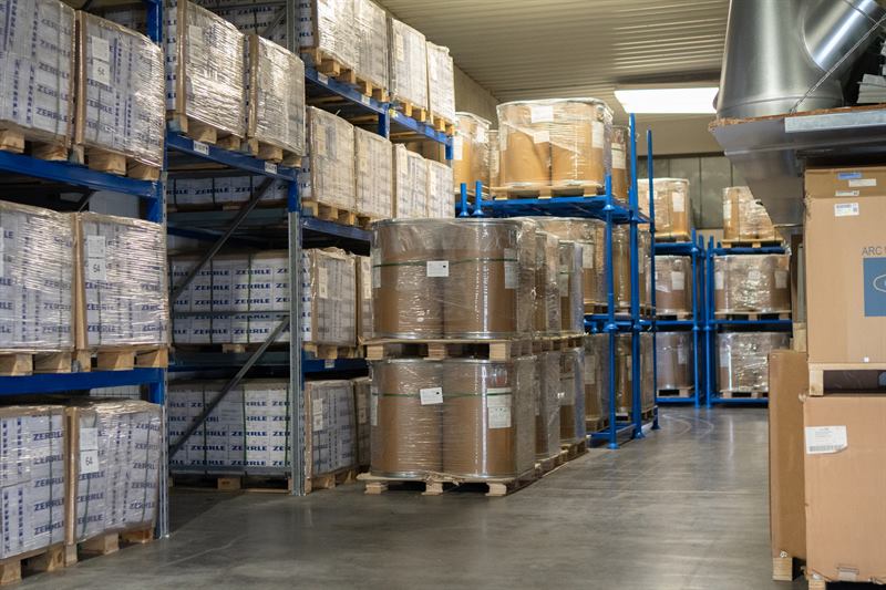 Lagerhalle mit Schweißdraht-Fassspulen und Palettenregalen