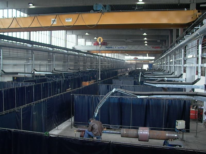 Fertigungshalle mit Schweißerkabinen und Absaugarmen