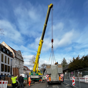 Baustellenkran entlädt Betonteile