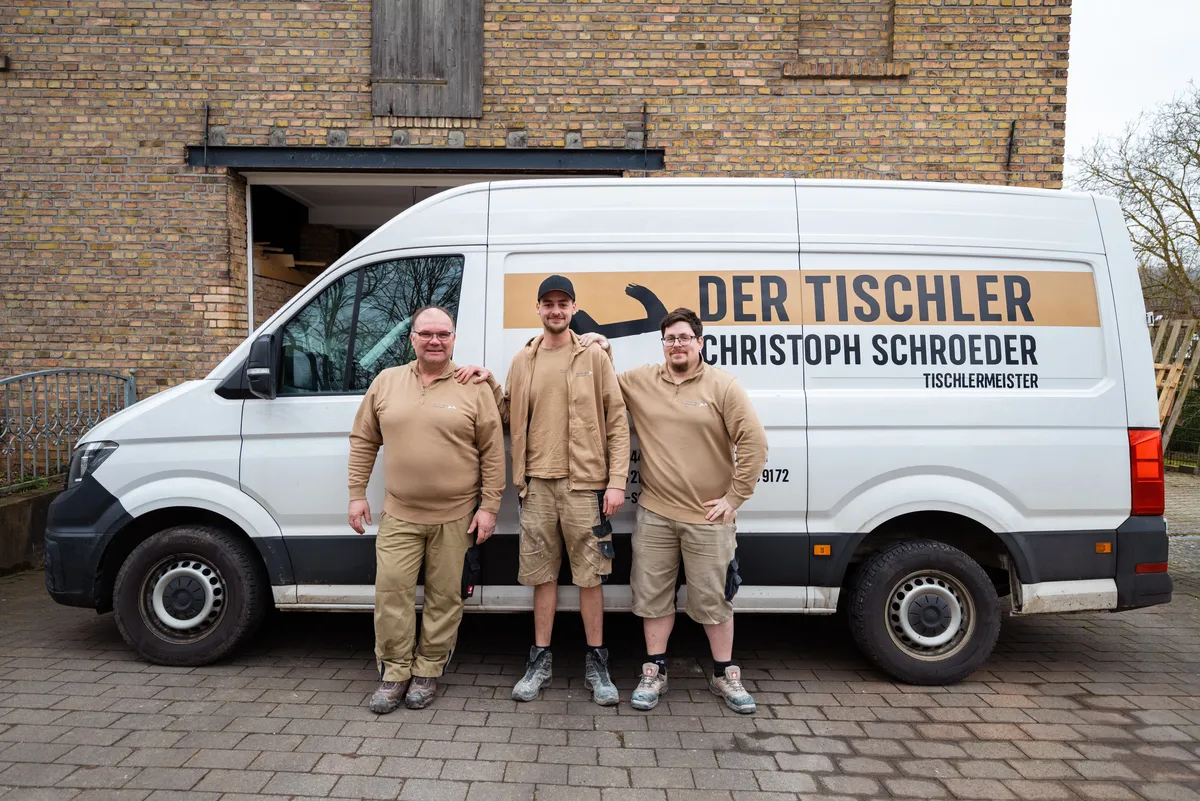 Team vor dem Firmenwagen