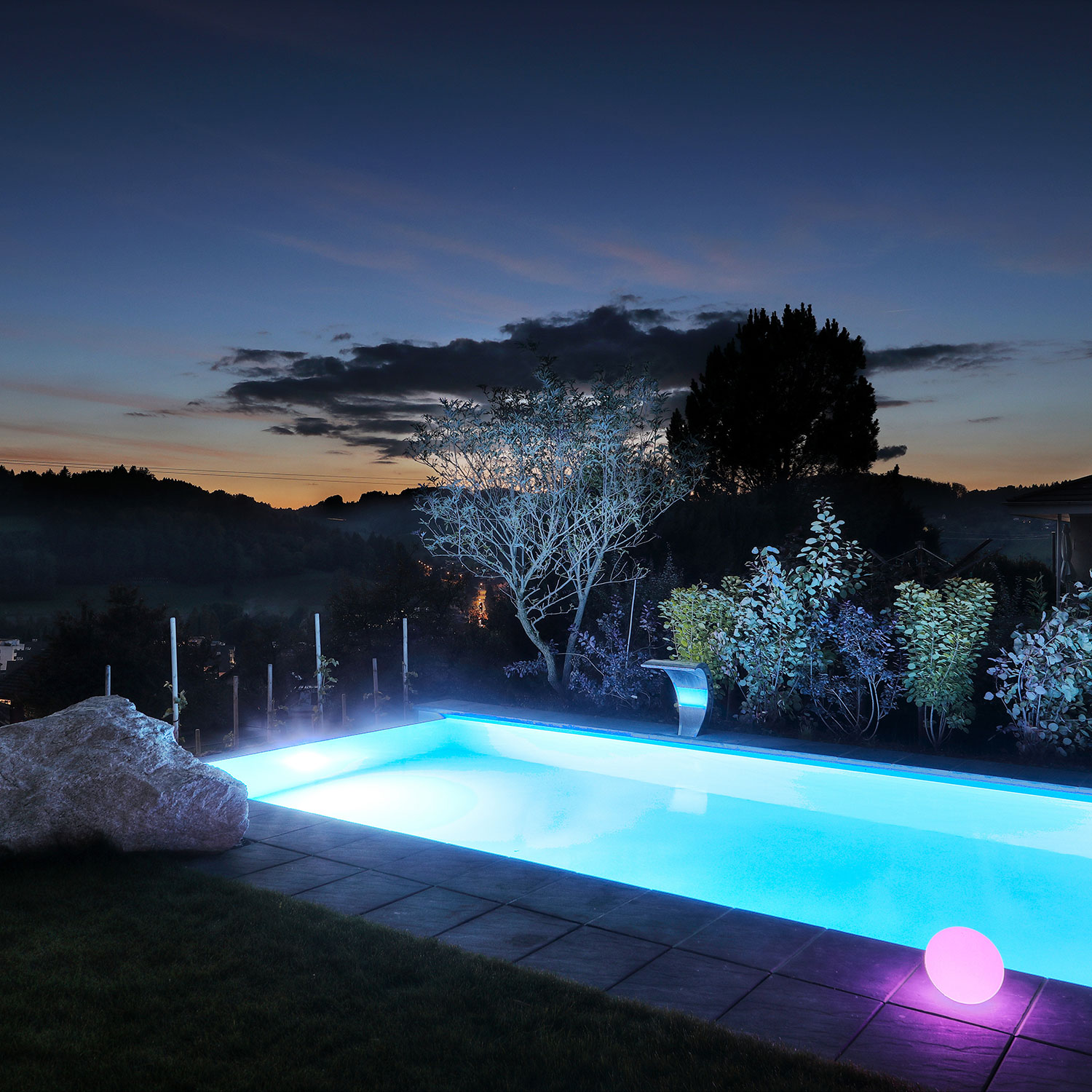 Beleuchteter Pool mit Blende in der Abenddämmerung