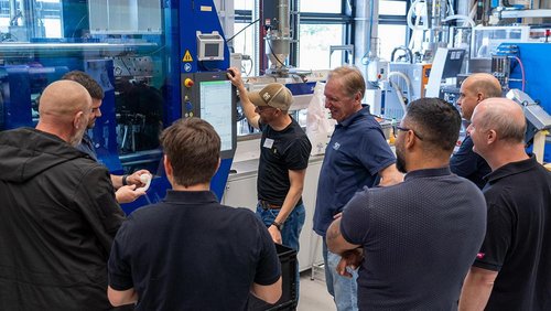 Team in front of an injection moulding machine