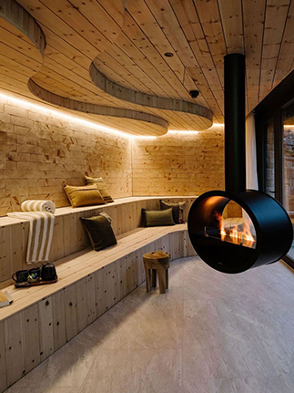 Spa-Bereich mit gebogenen Holzsitzbänken und freihängendem Kaminofen