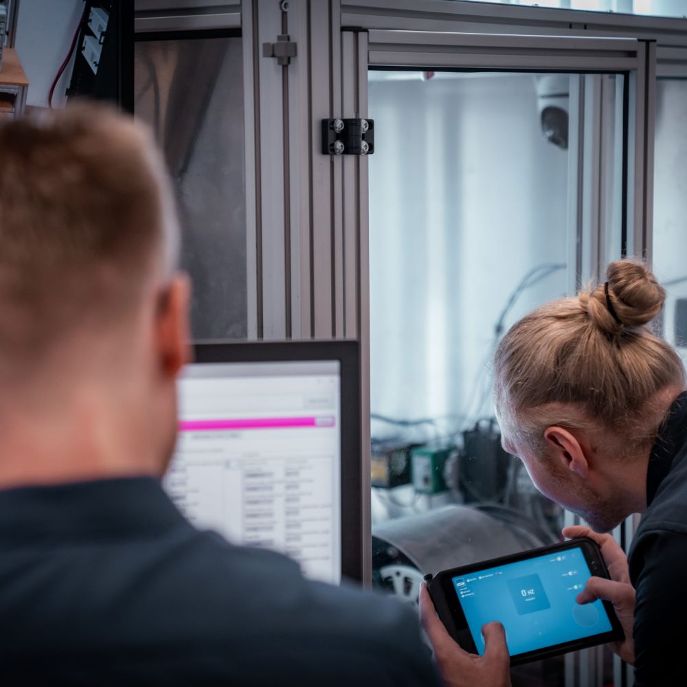 Team am Prüfstand mit Tablet