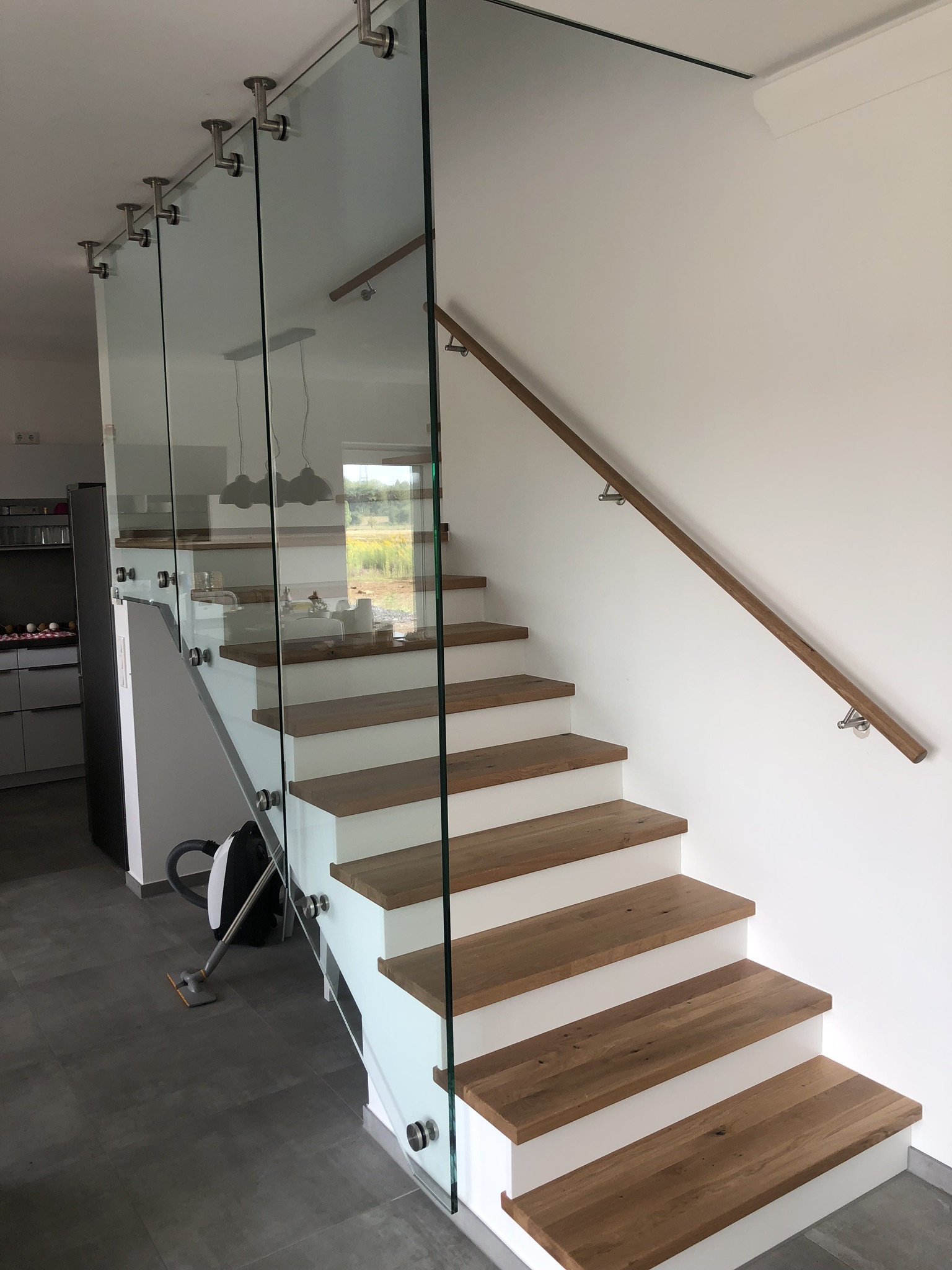 Betontreppe mit deckenhohem Glasgeländer