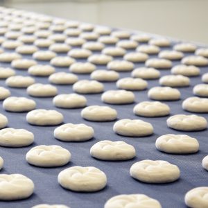 Ungebackene Semmel auf dem Lieferband einer Semmelanlage