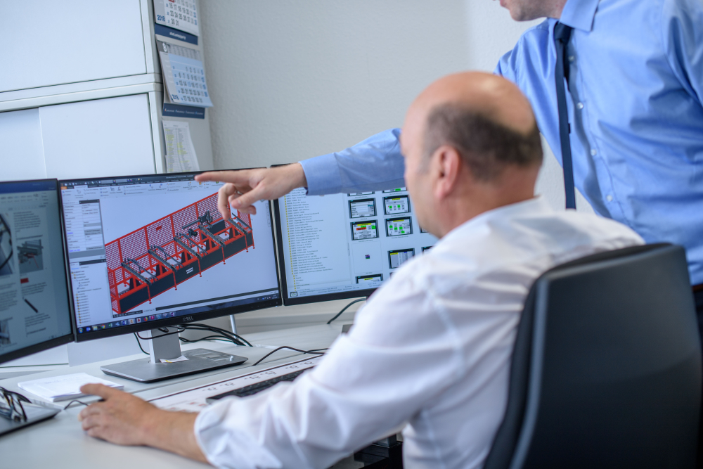 Engineers performing CAD design of sawing machines