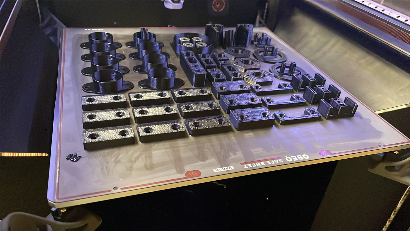 Technische Kunststoffteile auf dem Druckbett eines FDM-Druckers