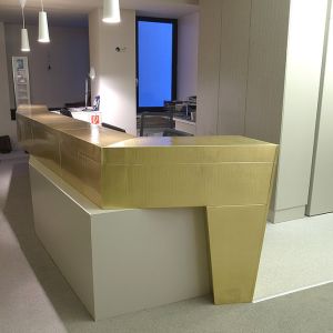 Empfangstresen aus strukturiertem Messingblech