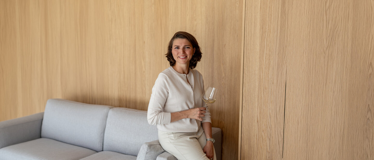 Gesine Roll mit einem Glas Chardonnay im Weingut