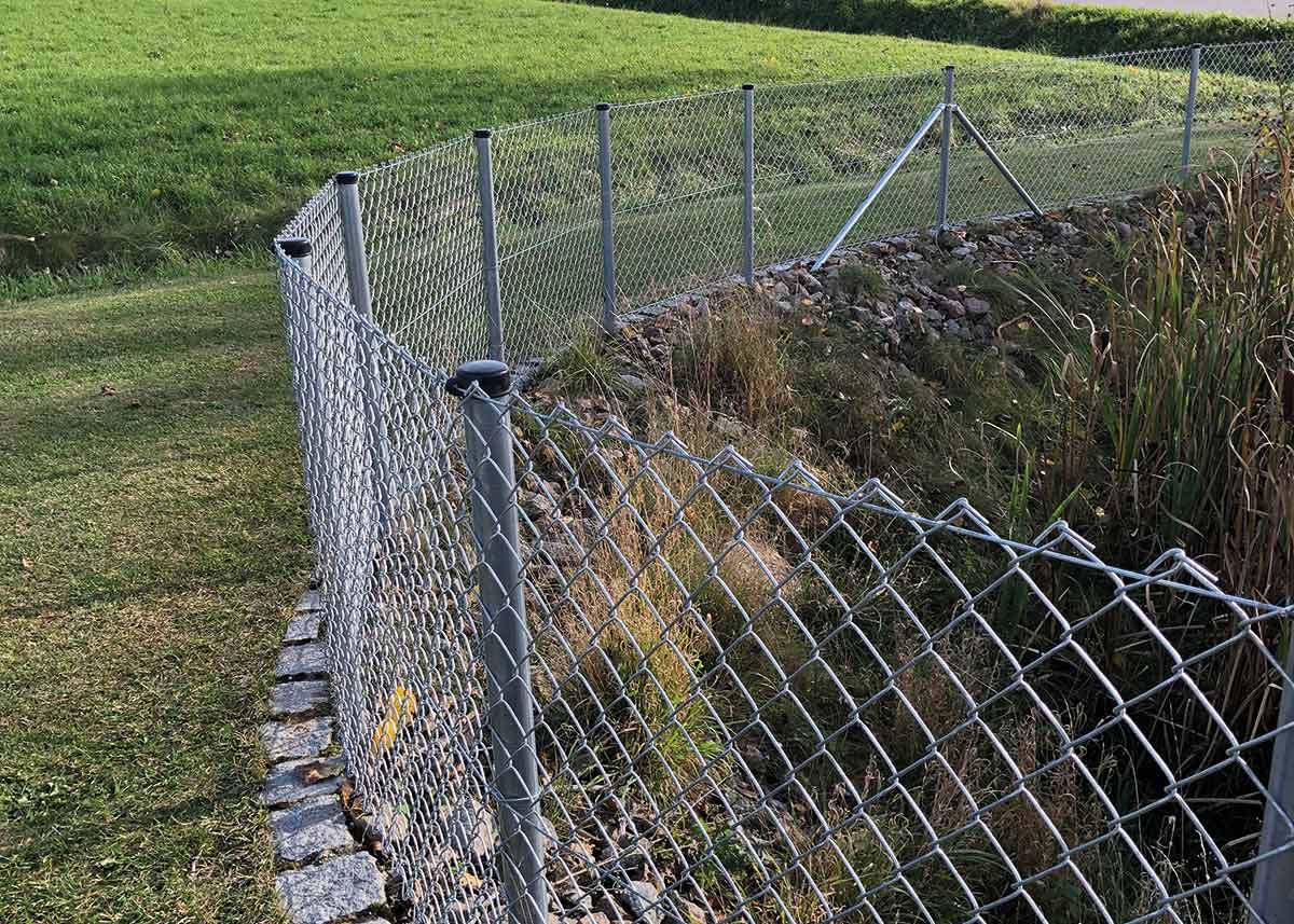 Maschendrahtzaun an Böschung