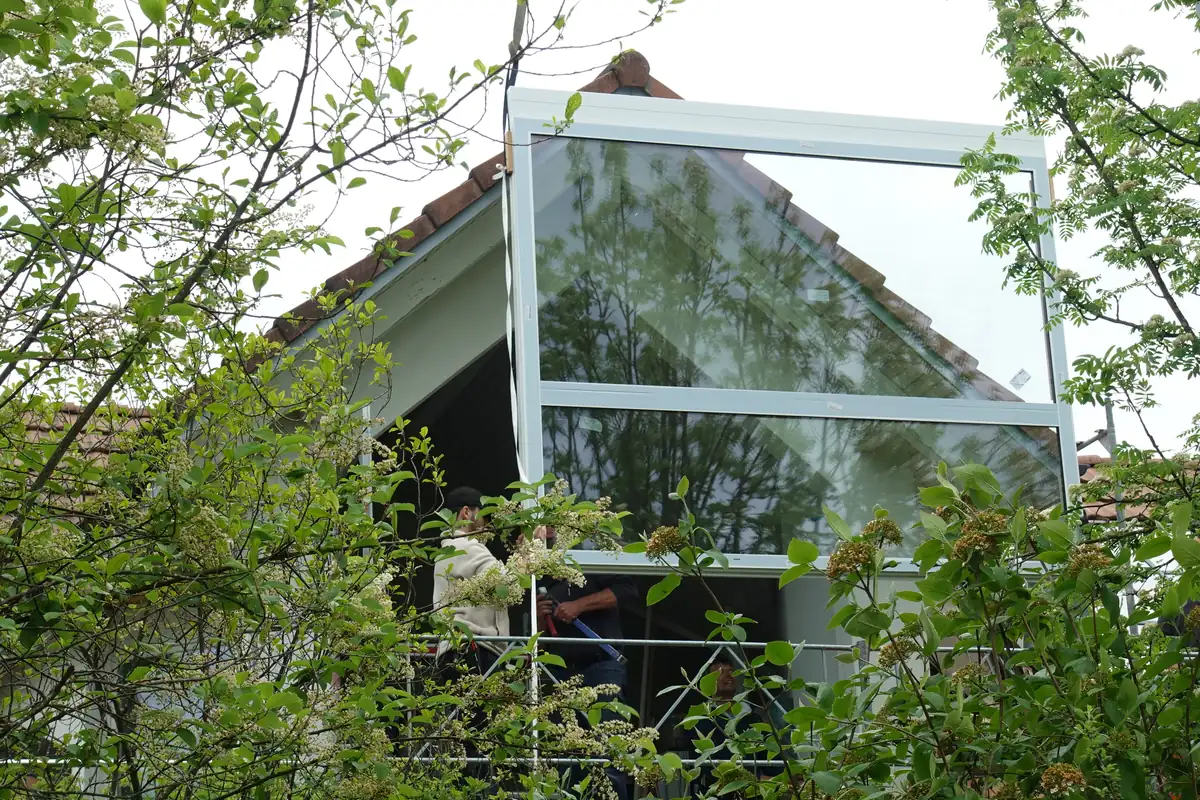 Large glass element being lifted in by crane over the roof