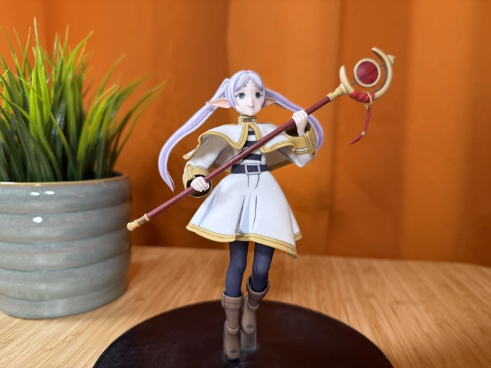 Figur mit Stab und weißem Mantel