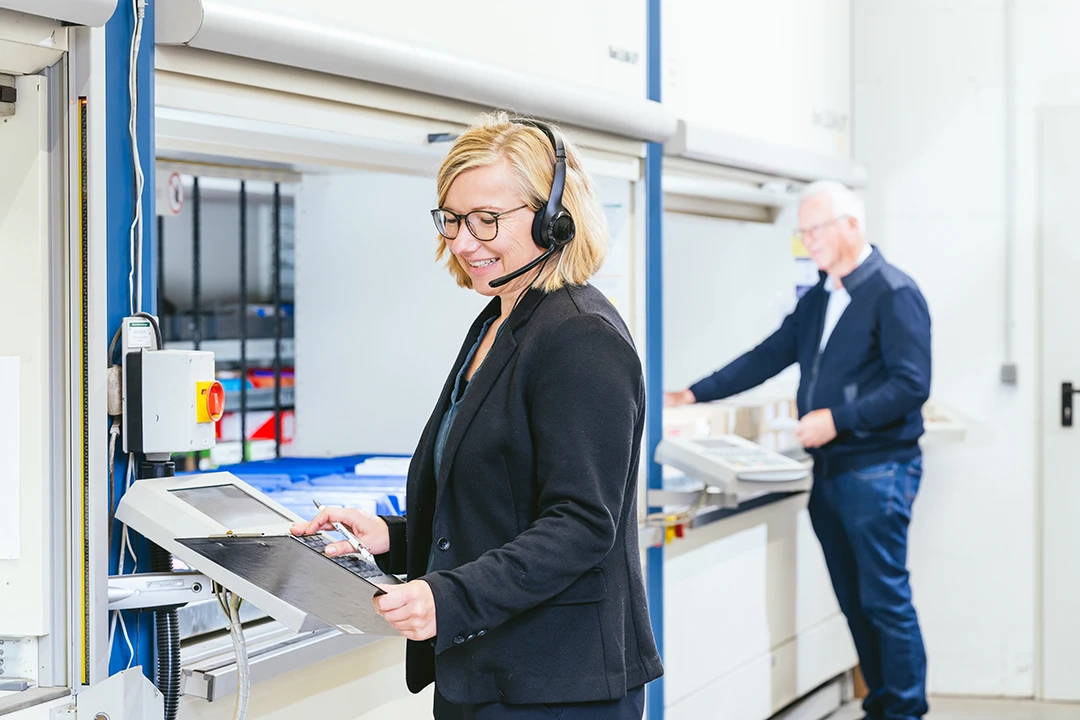 Mitarbeitende bedienen eine Maschine