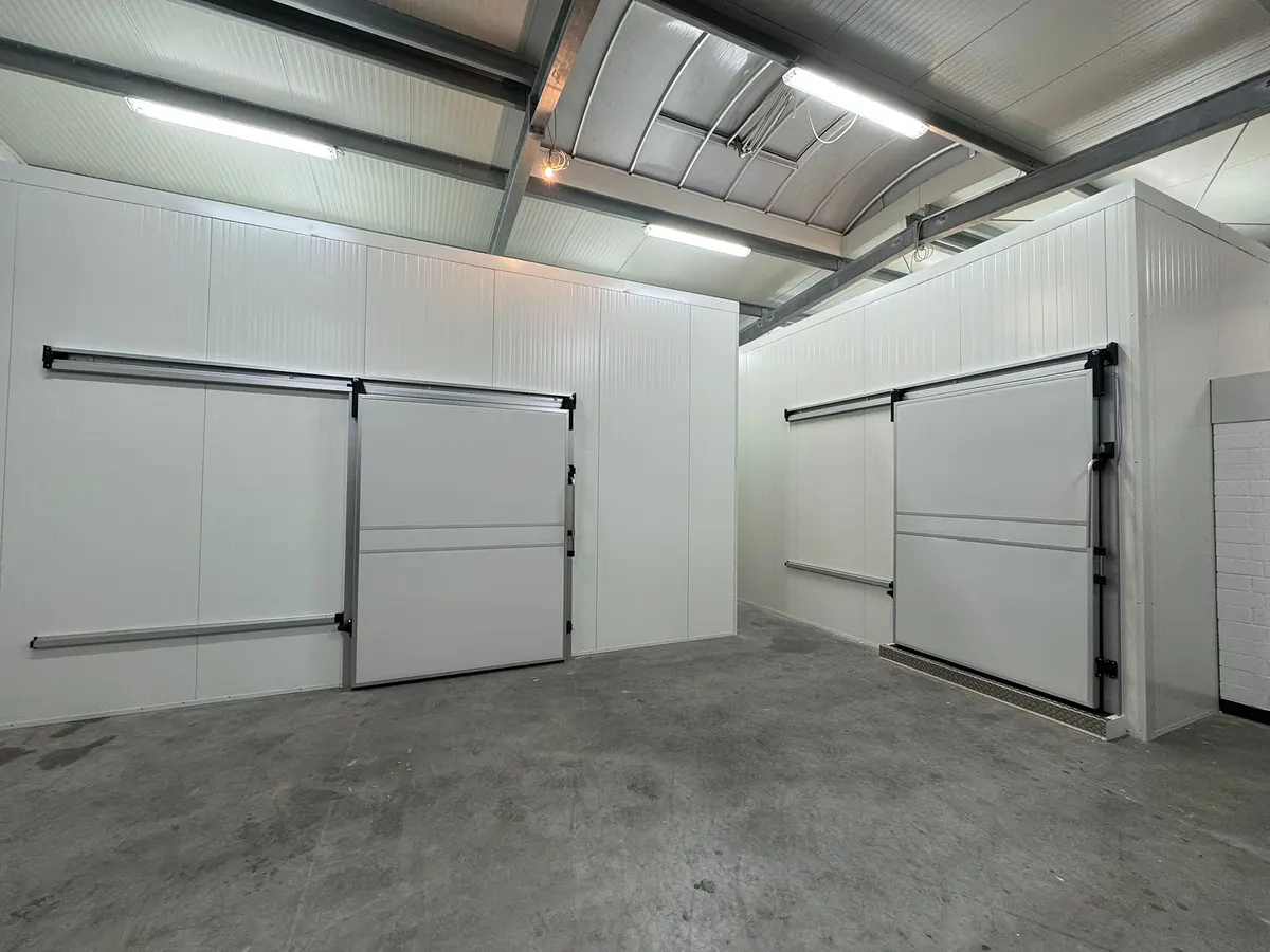 Zwei Kühlzellen mit Kühlhaus-Schiebetüren in einer Industriehalle