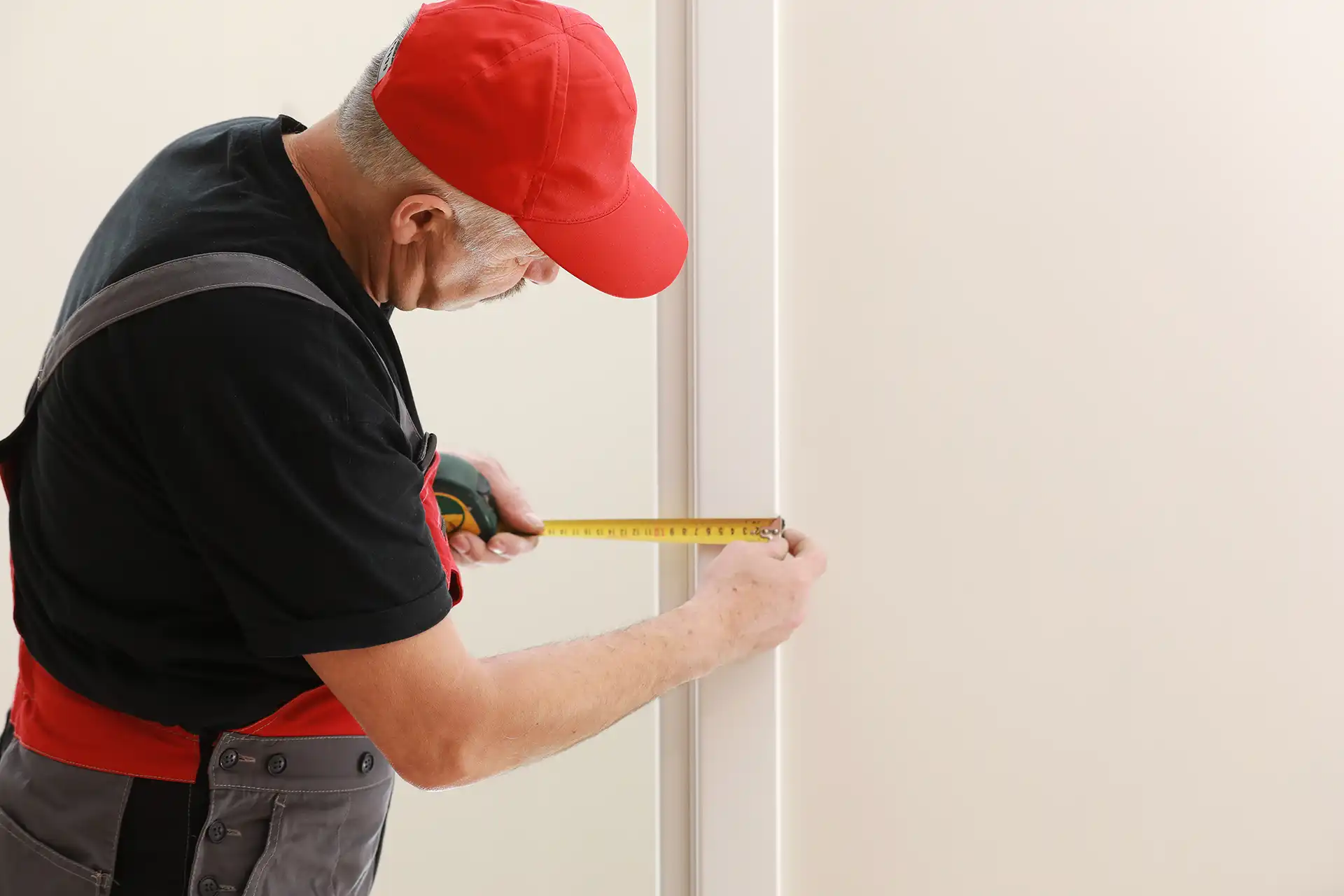 Handwerker misst Türzarge für den Innentüreinbau