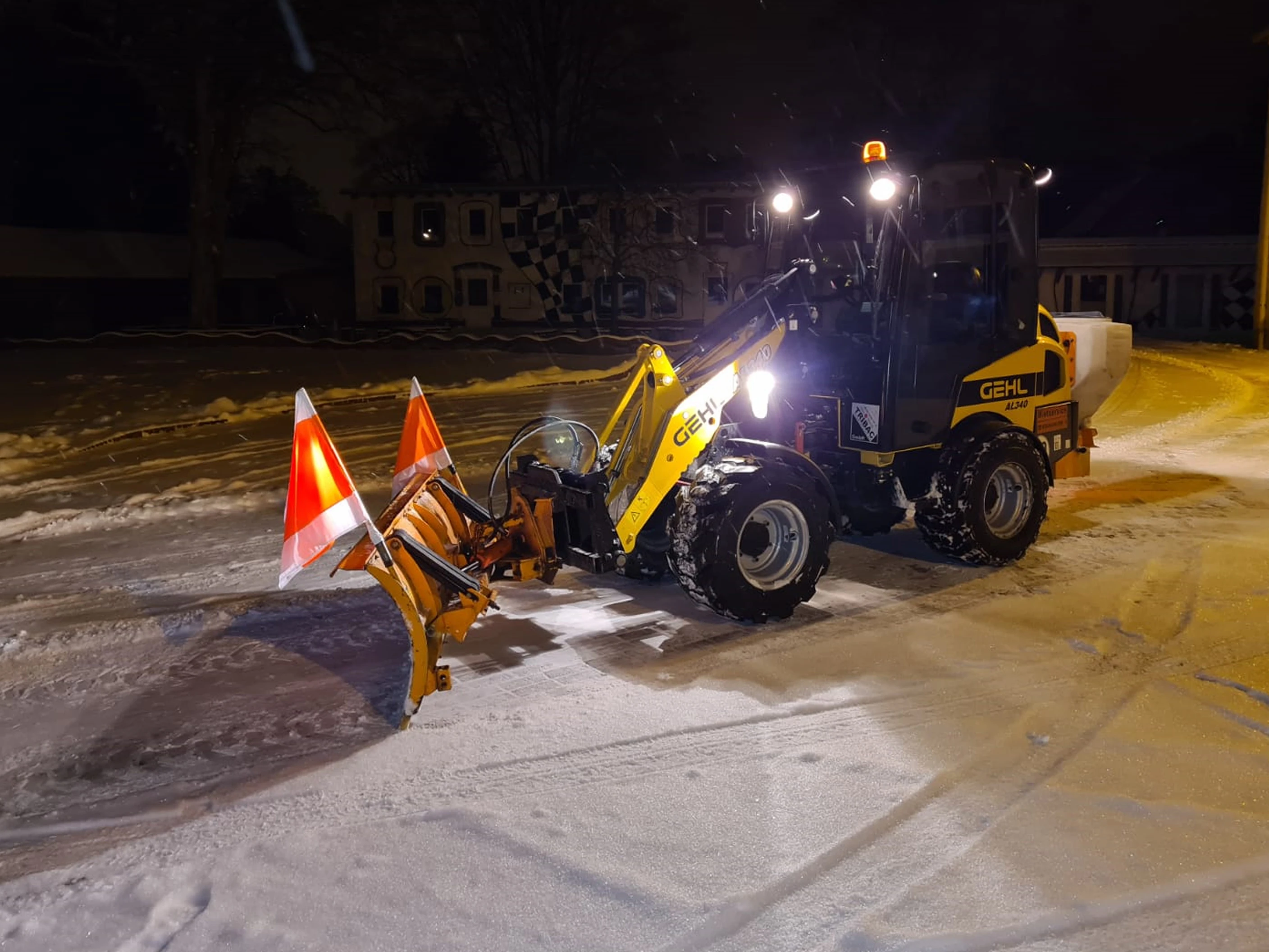 Knicklader GEHL AL340 mit Schneeschieber und Streuer