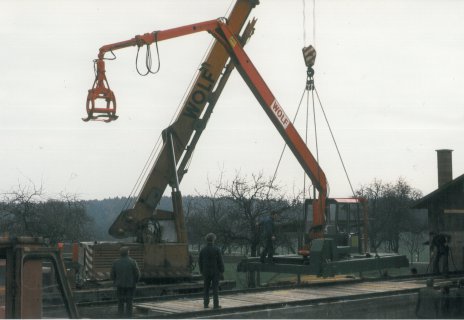 Rundholz-Sortierkran wird mit einem Kranwagen auf die Schienen gesetzt