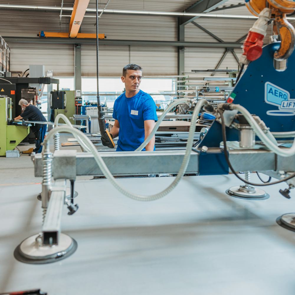 Metallbau: Mitarbeiter bedienen den Vakuumheber