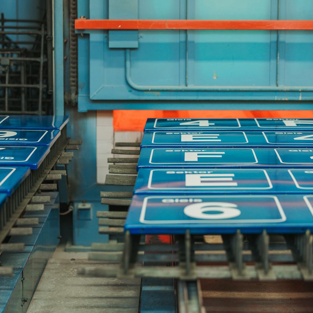 Emailleschilder werden in den Ofen geschoben