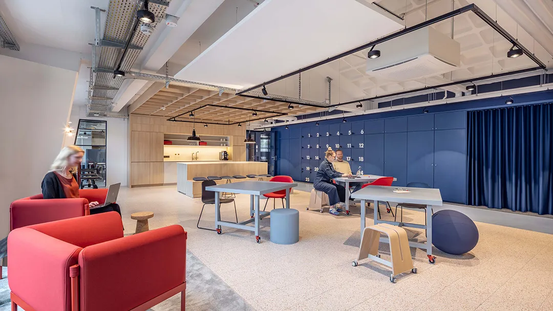 Flexibles Büro mit roten Sesseln und gemeinsamer Arbeitszone