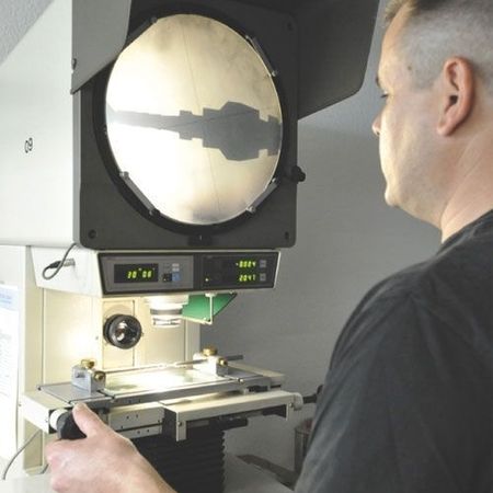 Mitarbeiter bei der Prüfung von Drehteilen