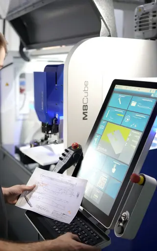 Mitarbeiter an der Steuerung einer CNC-Fräsmaschine