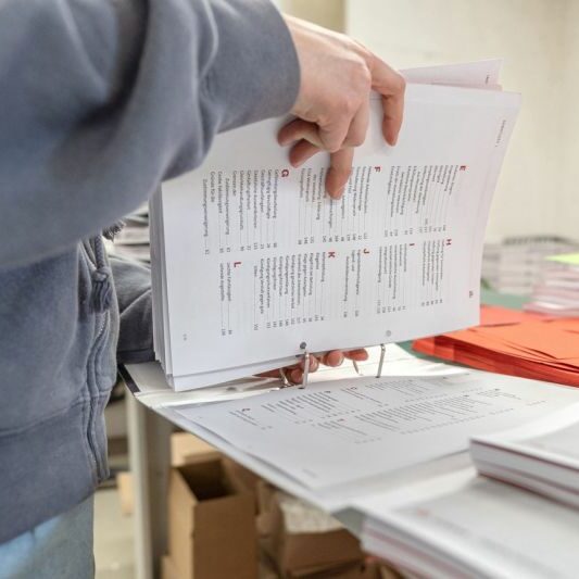 Handarbeit bei der Ordnerkonfektionierung in Murnau