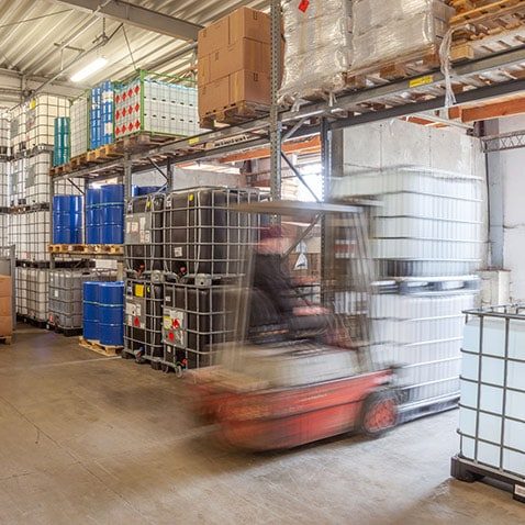 Lager mit IBC, Fässern und Gabelstapler