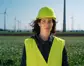 Mitarbeiterin der Windkraft vor einer Windkraftanlage