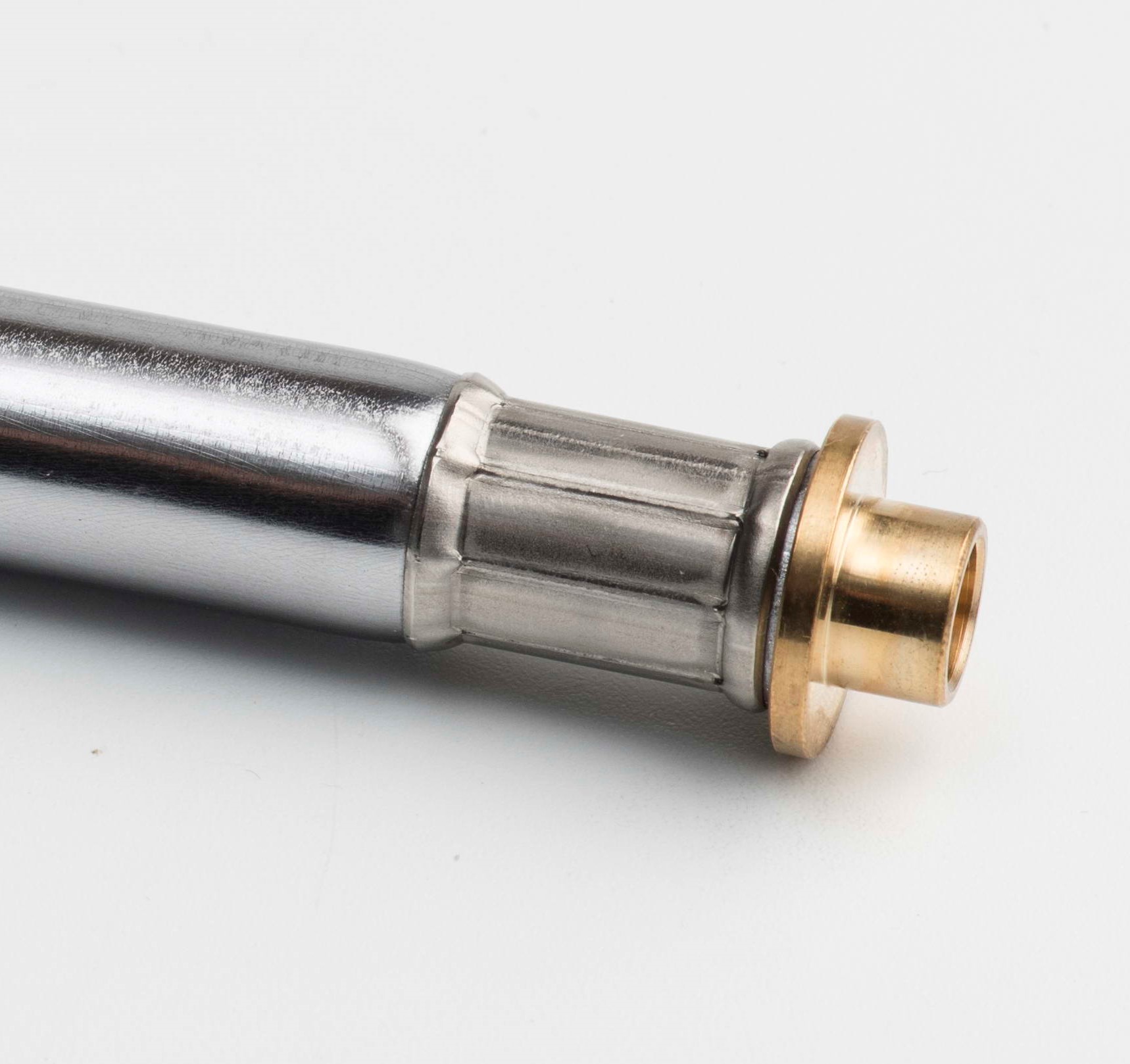 Zylindrisches Metallbauteil mit eingerollter Anschlussbuchse
