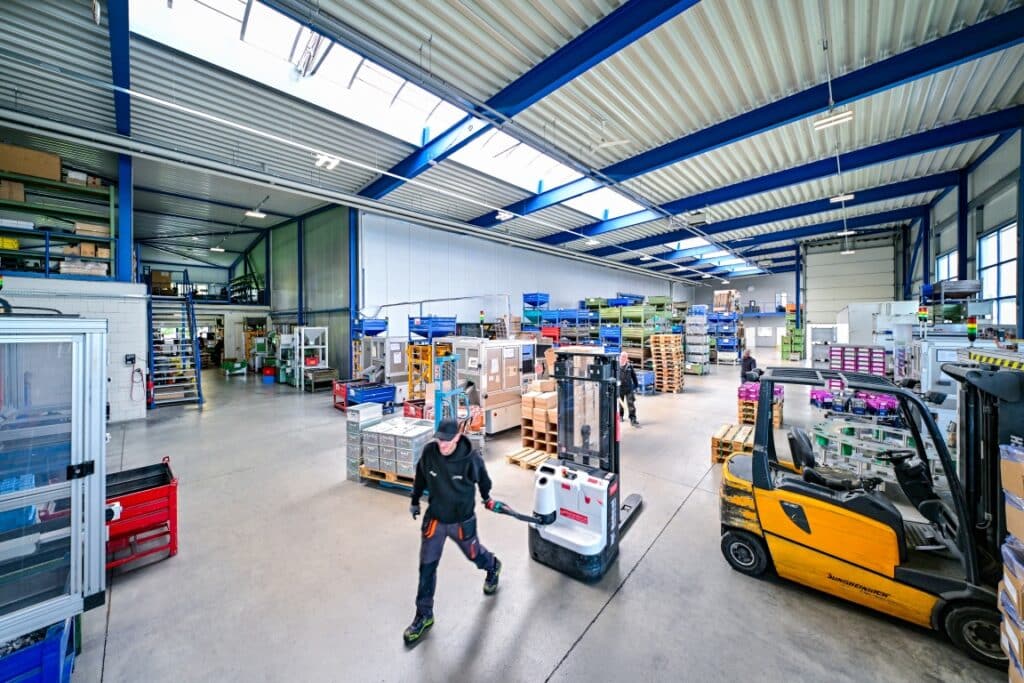 Lagerhalle mit Gabelstapler und Mitarbeitern