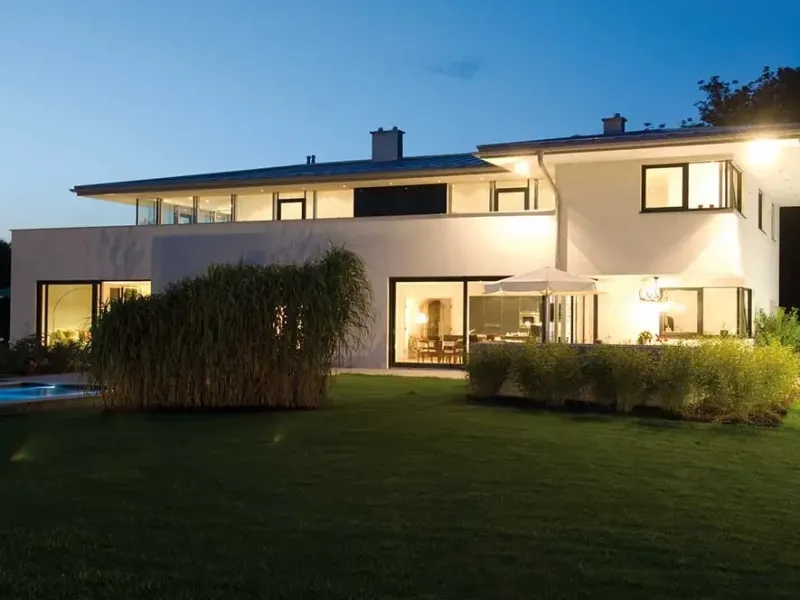 Modernes Einfamilienhaus mit großen Glasfronten am Abend