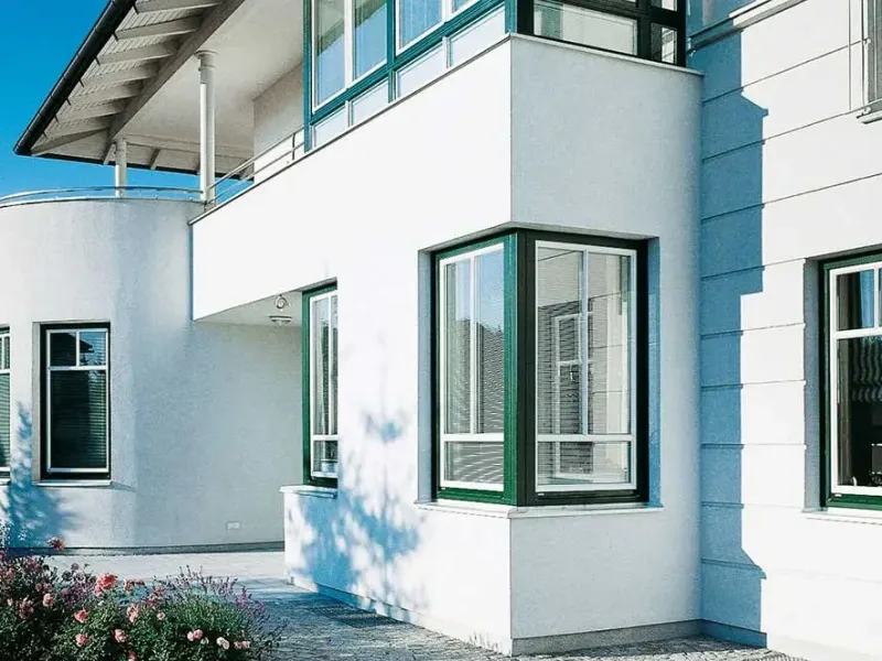 Wohnhaus mit grünen Fenstern und Erker