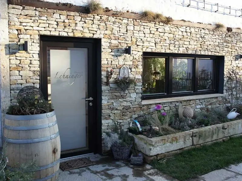 Haus mit Natursteinfassade und Eingangstür mit Glas