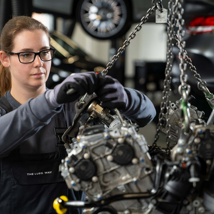 Female mechanic performing engine work in the workshop