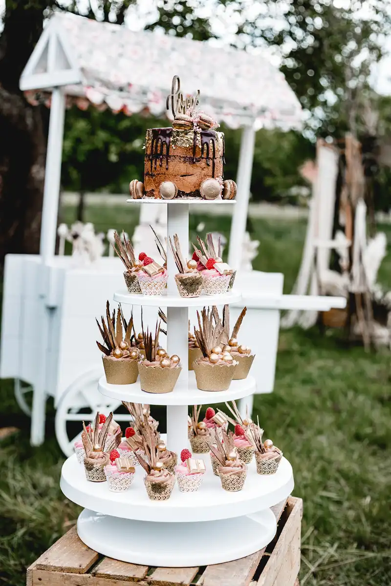 Drip Cake mit Macarons und goldenen Cupcakes