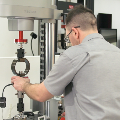 Instron-Techniker bei der Kalibrierung eines Universalprüfsystems