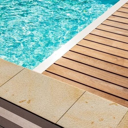 Schwimmbecken mit Holzbohlen und Steinplatten