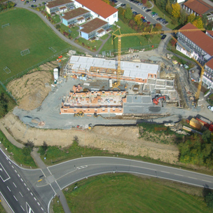 Luftaufnahme einer Baustelle mit Kran und Baumaschinen
