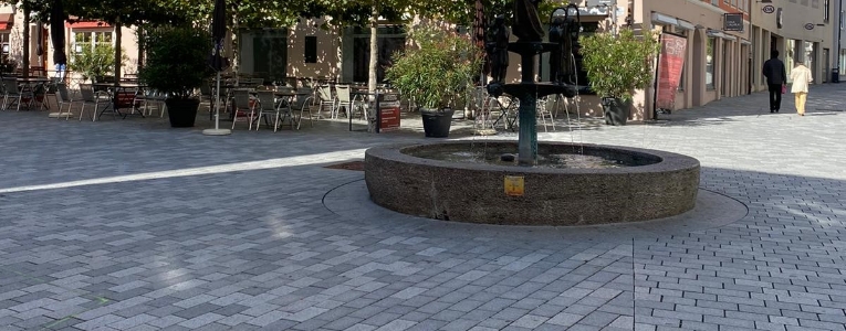 Steinbrunnen auf Natursteinpflaster