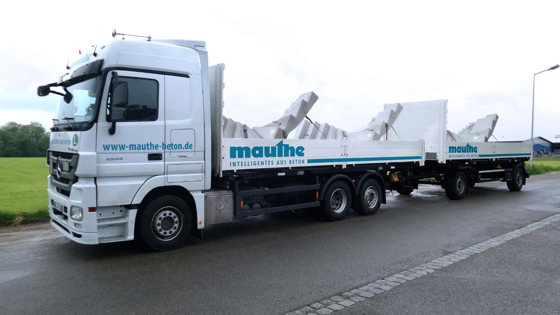 Mauthe-LKW mit Betonfertigteiltreppe und Redi-Rock Stein