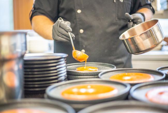 Koch garniert Kürbiskernsuppe